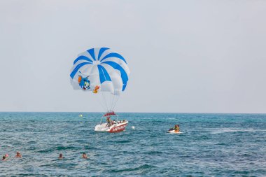 Kalabalık denizde paraşütle kayık 