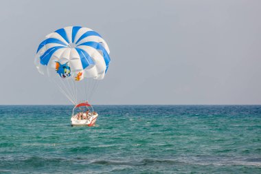 Kalabalık denizde paraşütle kayık 