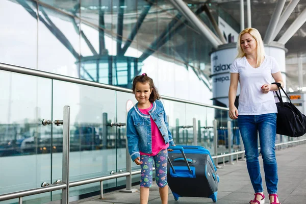 带着行李在机场的年轻母亲和女儿 — 图库照片