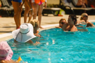 Bir grup insan havuzda eğleniyor. 