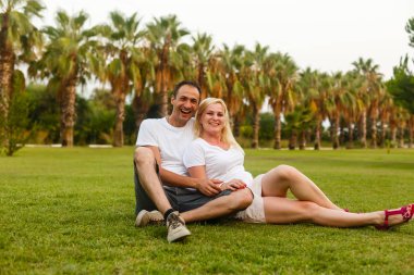 Yeşil tropikal parkta dinlenmek genç mutlu çift