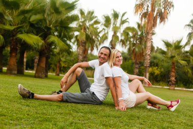 Yeşil tropikal parkta dinlenmek genç mutlu çift