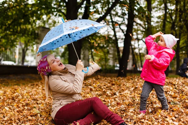 Sonbahar parkında eğlenmek Genç Anne ve yürümeye başlayan kız