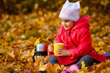 Gülümseyen kız termos Sonbahar Park üzerinden çay içme