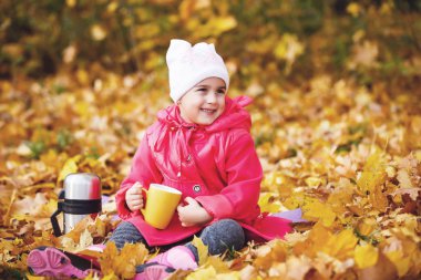 Gülümseyen kız termos Sonbahar Park üzerinden çay içme