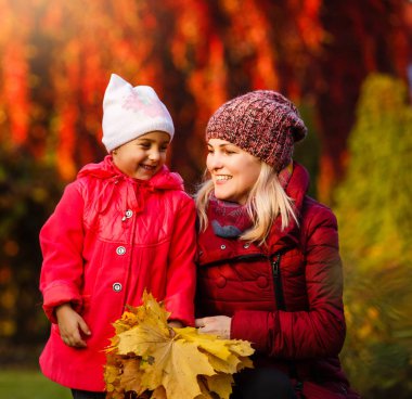 Anne ve kızı Sonbahar Park sarı yaprakları ile