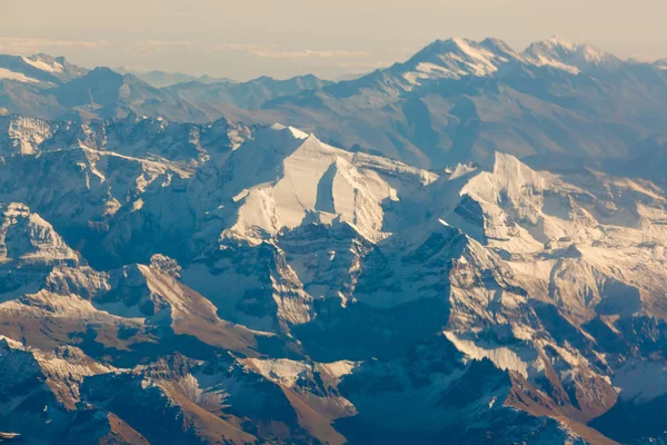 スイスアルプスのパノラマビュー 飛行機の窓からの眺め  — 無料ストックフォト