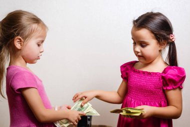 Beyaz arka planda dolar larla oynayan iki küçük kız