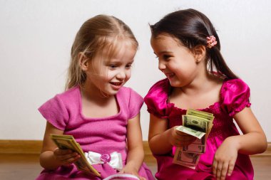 Beyaz arka planda dolar larla oynayan iki küçük kız