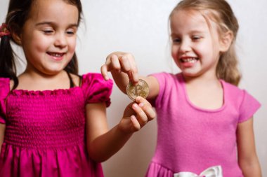 beyaz arka planda bitcoin ile iki küçük kız