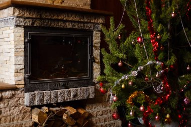 Şömine nin yanında dekore edilmiş Noel ağacının yakın görünümü