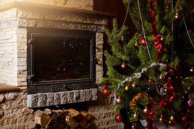Şömine nin yanında dekore edilmiş Noel ağacının yakın görünümü