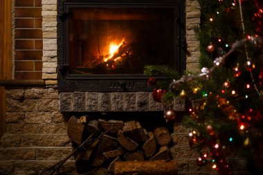 Şömine nin yanında dekore edilmiş Noel ağacının yakın görünümü