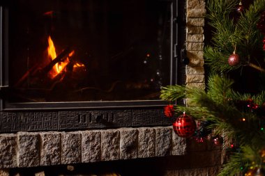 Şömine nin yanında dekore edilmiş Noel ağacının yakın görünümü