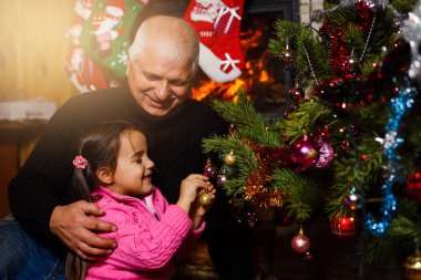 Noel iç Noel ağacı yakınındaki torunu ile oynarken Büyükbaba