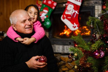 Noel iç Noel ağacı yakınındaki torunu ile oynarken Büyükbaba