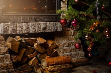 Şömine nin yanında dekore edilmiş Noel ağacının yakın görünümü