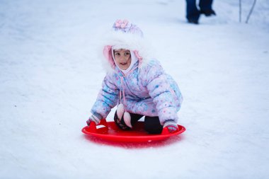 Mutlu kız oynarken ve karlı kış parkı çalışan
