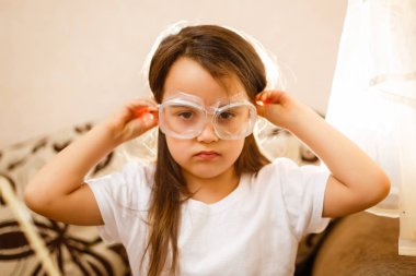 Küçük kız koruyucu gözlük ile İlköğretim Fen Bilgisi dersinde deney