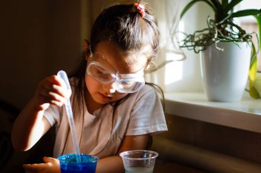 Küçük kız koruyucu gözlük ile İlköğretim Fen Bilgisi dersinde deney