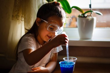 Küçük kız koruyucu gözlük ile İlköğretim Fen Bilgisi dersinde deney