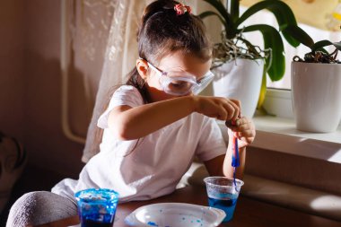 Küçük kız koruyucu gözlük ile İlköğretim Fen Bilgisi dersinde deney