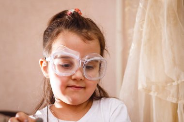 Küçük kız koruyucu gözlük ile İlköğretim Fen Bilgisi dersinde deney