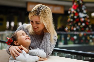 Noel 'de alışveriş merkezinde mutlu bir anne ve kız. 