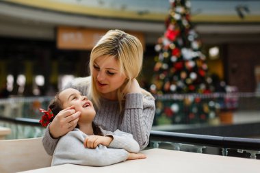 Noel 'de alışveriş merkezinde mutlu bir anne ve kız. 