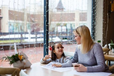 Noel dekore kafede küçük kızı ile genç anne