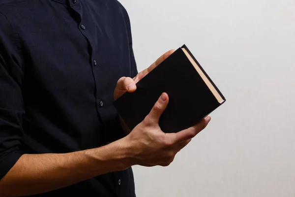 Человек Черной Рубашке Держит Священную Библию Белом Фоне — стоковое фото