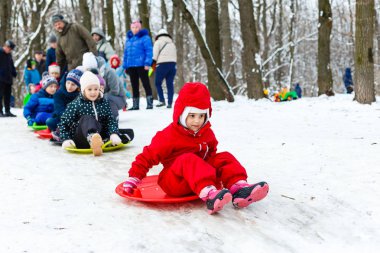 Küçük kız açık havada kayıyor.