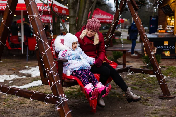 Jonge Moeder Met Kleine Dochter Zittend Swingende Kerst Bank Park — Stockfoto