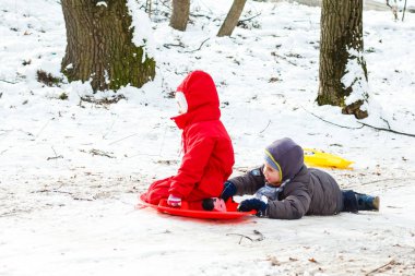 Mutlu aile kış parkında karda oynuyor.