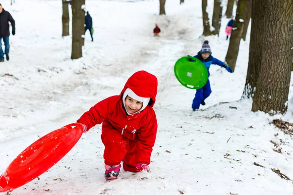 Smiling Girl Red Ski Suit Sliding Snow Covered Hill Sledge — Stock Photo, Image