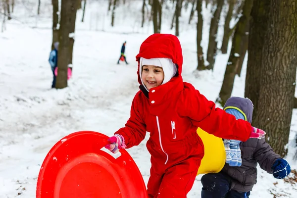 Smiling Girl Red Ski Suit Sliding Snow Covered Hill Sledge — Stock Photo, Image