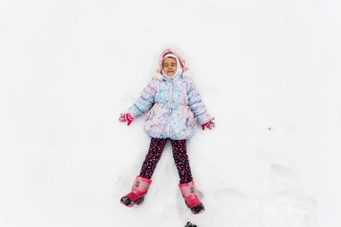 Karlı kış parkında oynayan mutlu kız