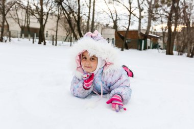 Kabarık ceket karlı sahada oynayan küçük kız