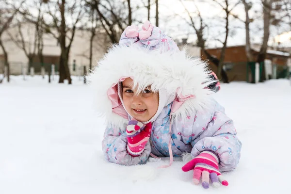 穿着蓬松外套在雪地操场上玩耍的小女孩 — 图库照片