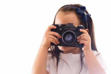 Beyaz arka planda retro kamera tutan küçük kız 