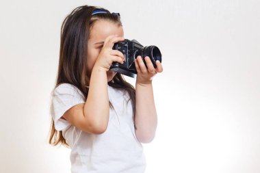Beyaz arka planda retro kamera tutan küçük kız 