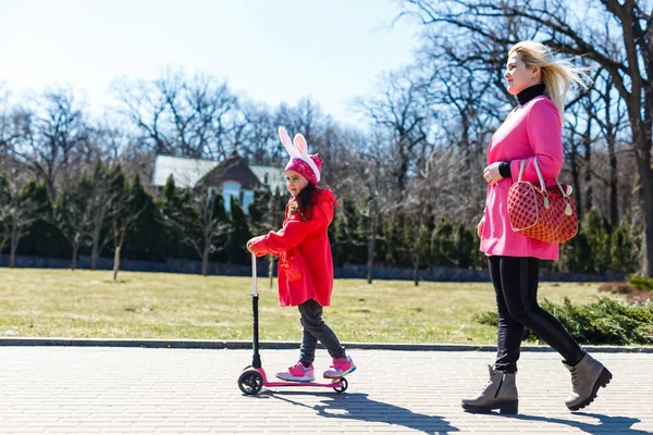 Liten Flicka Ridning Skoter Och Mor Går Bredvid Parken — Stockfoto