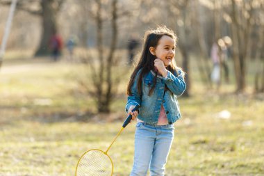 küçük kız badminton oynarken bahar çayır on