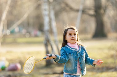 küçük kız badminton oynarken bahar çayır on