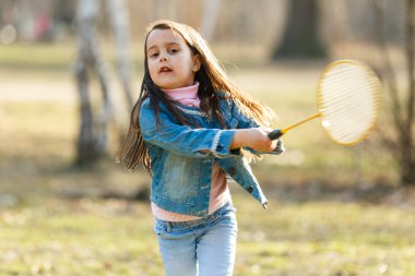 küçük kız badminton oynarken bahar çayır on