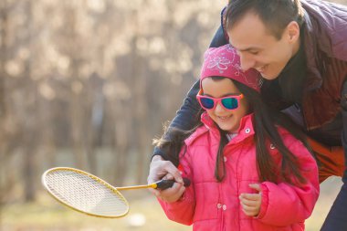 Baba badminton oynamak için kızı öğretim