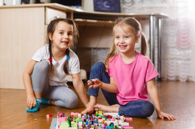 Evde erector seti ile oynayan iki küçük kız