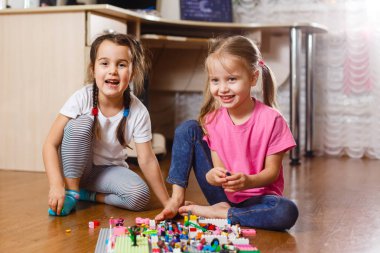 Evde erector seti ile oynayan iki küçük kız