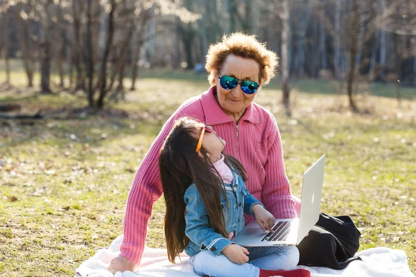 Ragazza Con Nonna Utilizzando Computer Portatile Nel Parco Primaverile — Foto Stock