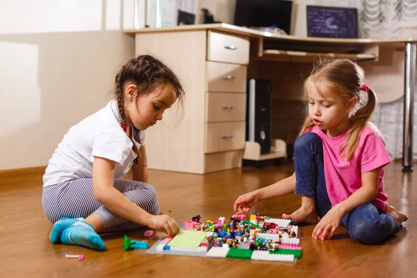 自宅で設定されたエレクターで遊ぶ2人の小さな女の子 — ストック写真